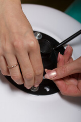 The woman collects a computer chair on wheels. Parts for the office chair are on the floor in the apartment. Close-up shot.