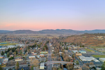 Peaceful town surrounded by trees with mountains as background