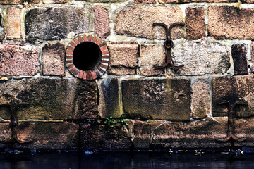 Medieval sewage pipe in the wall at the historic harbor Port of the Hanseatic City of Lueneburg