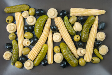 Olives, pickled cucumber, mushrooms and corn in a salad on a plate. food and vegetables. diet and weight loss