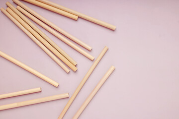 Reusable bamboo straws on the pink background,