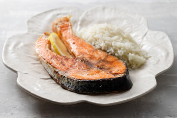 fried salmon with boiled rice on the dish