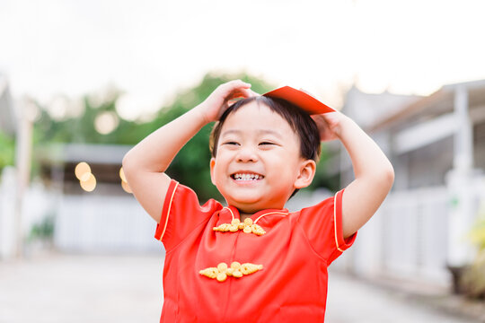 Happy Chinese New Year Kid Boy.Asian Toddler Boy Wearing Chinese Traditional Cheongsam Qipao Shirt Showing Red Envelope At Home.Happy Chinese New Year Concept.Holidays In Asian People.Stay Home Save.