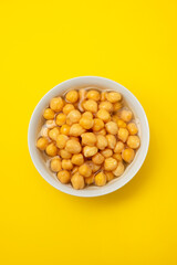 boiled chick pea in white bowl on yellow background