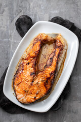 Fototapeta na wymiar gried salmon on white dish on ceramic background
