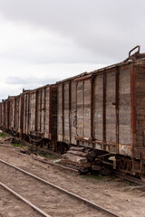 Obraz premium Old and rusty wooden train car abandoned on a railway track. Bolivia