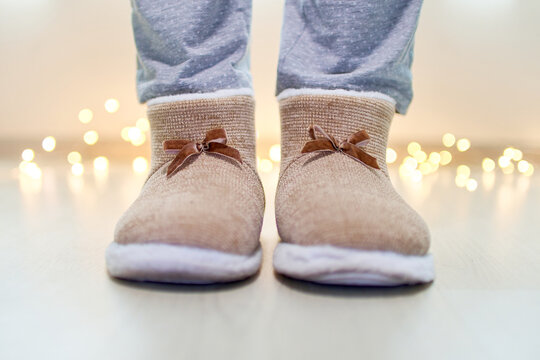 Female Legs Wearing Warm Fluffy Soft Winter Slippers At Comfy Home