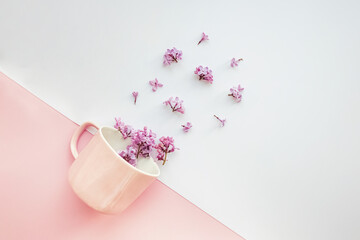 Layout made of pink coffee cup with smal lilac flowers