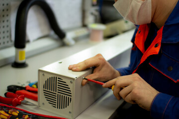 Assembly of the air purifier.An employee repairs air conditioners and air purifiers.