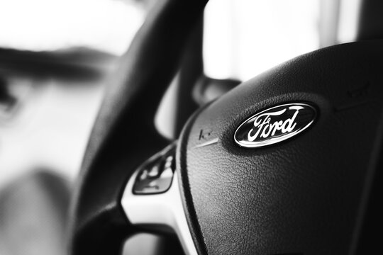 Ford, carros. Volante de um Ford Ka com foco no logotipo da empresa em fotografia em preto e branco.