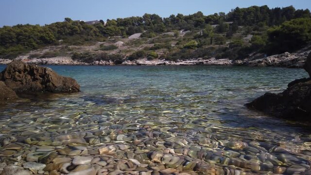 View of clear waters and smooth pebbles of Svitnja beach on the island of Vis in Croatia