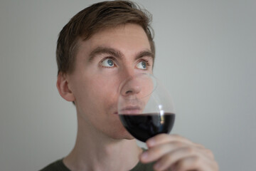 young man tasting red wine