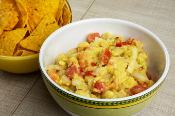 guacamole with tortillas on wooden table