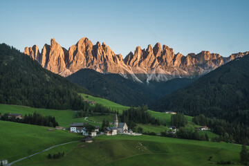 Beautiful view of the Puez Odle National Park and the Santa Magdalena Church at sunset, Dolomites, Italy