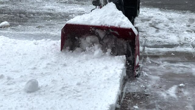 Snow blower being used to clear the driveway after a snow storm