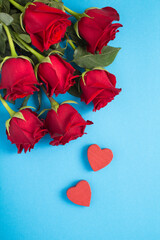 Top view of red roses and hearts on the blue background