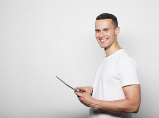 Young man wearing white t-shirt using a tablet computer