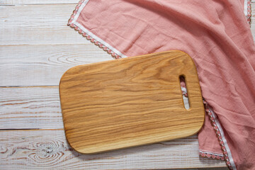 Wooden cutting board and pink tablecloth napkin - italian cuisine concept.