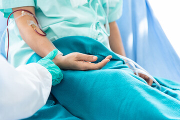 Fototapeta premium Doctor checking pulse and heart rate on patient wrist in the hospital.