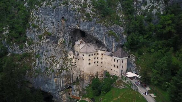 Flying closer to Predjama Castle, built inside cave mouth in Slovenia