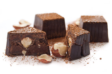 Broken chocolate candies with hazelnut inside on a white background