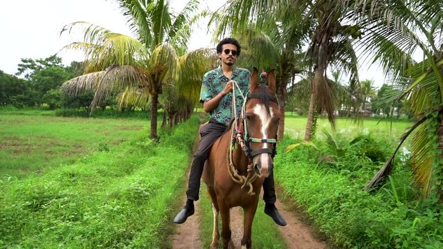 Young handsome man with brown horse. man riding horse