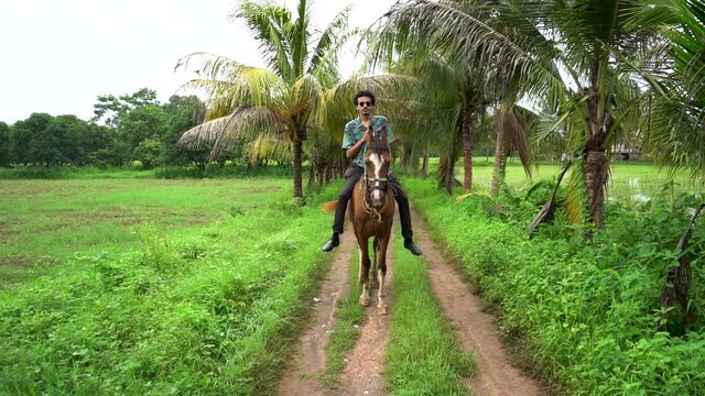 Young handsome man with brown horse. man riding horse