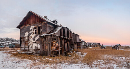 Abandoned house against the Arctic sky. Old authentic village of Teriberka. Kola Peninsula.