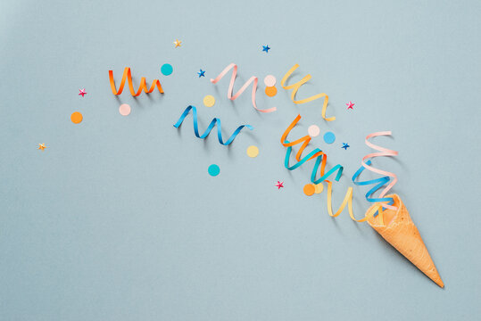 Colorul party streamers on blue background. Celebration concept. Flat lay.
