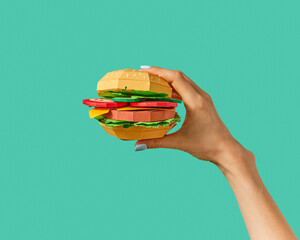 Handcraft paper hamburger in a hand.