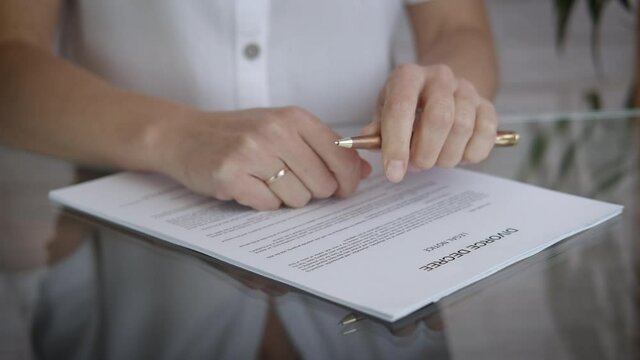 Divorce documents. A woman want to divorce and puts her ring on the divorce documents.