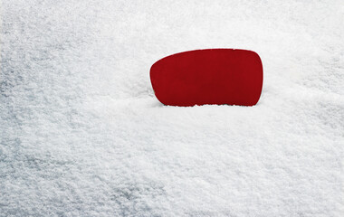 Red sign without inscription. Blank placard with space for your text. In the background you can see white snow. The sign is located on the right side of the frame