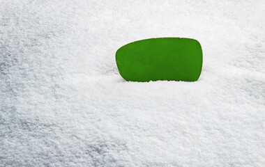 Green sign without inscription. Blank placard with space for your text. In the background you can see white snow. The sign is located on the right side of the frame