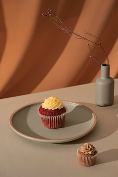 Delicious fresh red velvet cake on the table and vase with flowers.