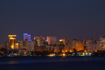 Fototapeta na wymiar Yekaterinburg skyline at night under the Moonlight reflecting in water of city pond