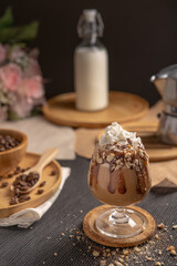 iced mocha coffee served with whipped cream topping and chocolate syrup in wine glass place on wooden table