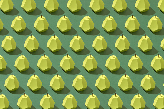 Pear fruit made of paper. Green background.