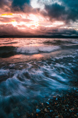 Obraz premium Waves of the lake at stormy sunset long exposure
