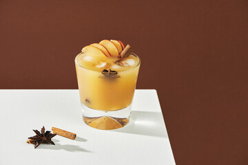 Apple cider cocktail with cinnamon and apple slices