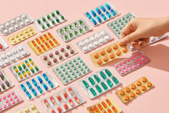 Hand holding remedy on pink background. Medicine.