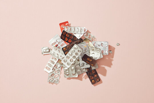Tablets in a blister pack used medicine and drugs isolated on pink.