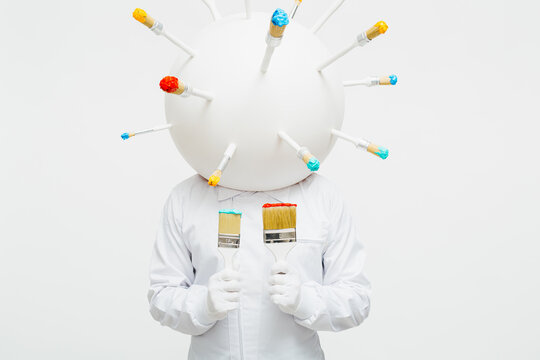 Artistic character with a big round head full of brushes working in his work.