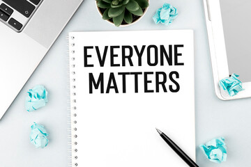 Text EVERYONE MATTERS on card with laptop, pieces of paper and pen on office desk . Flat lay, top view.