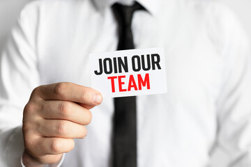Businessman holding in hand a card with text JOIN OUR TEAM