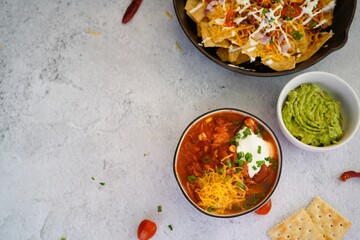 Skillet Turkey Chili Nachos topped with sourcream and guacamole