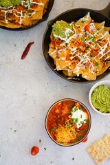 Skillet Turkey Chili Nachos topped with sourcream and guacamole