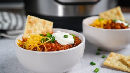 Homemade Turkey bean chili topped with sourcream cheese and green onions, selective focus