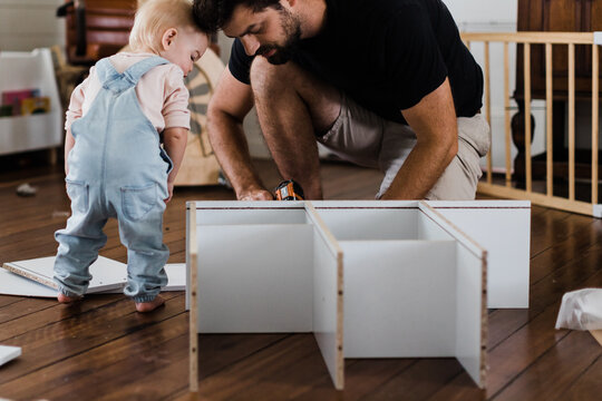 Father and daughter constructing shelves