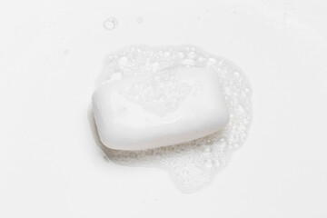 Soap bar and foam on white background