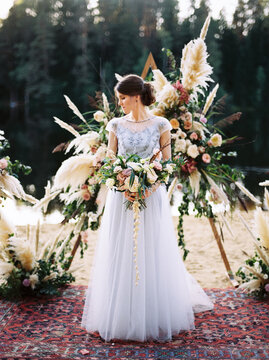 Bride near arch for wedding ceremony